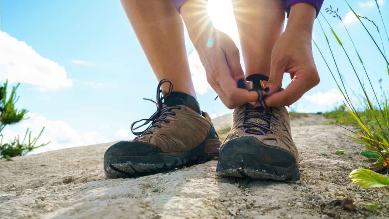 Hiker tying shoe laces
