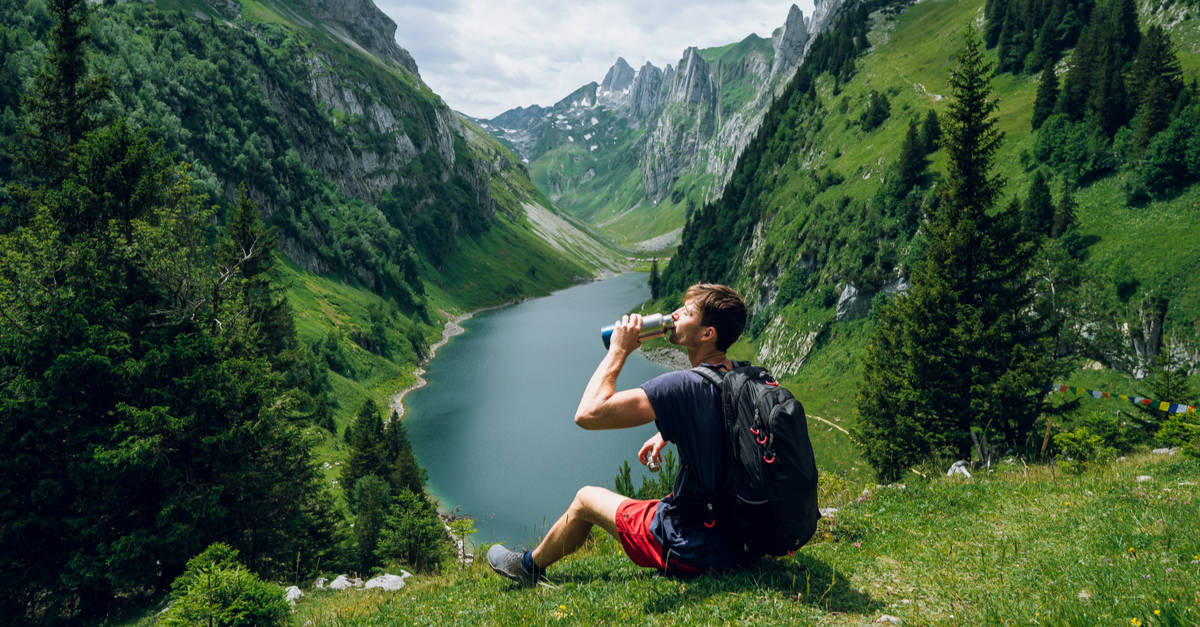 Hiker drinks from a stainless steel bottle