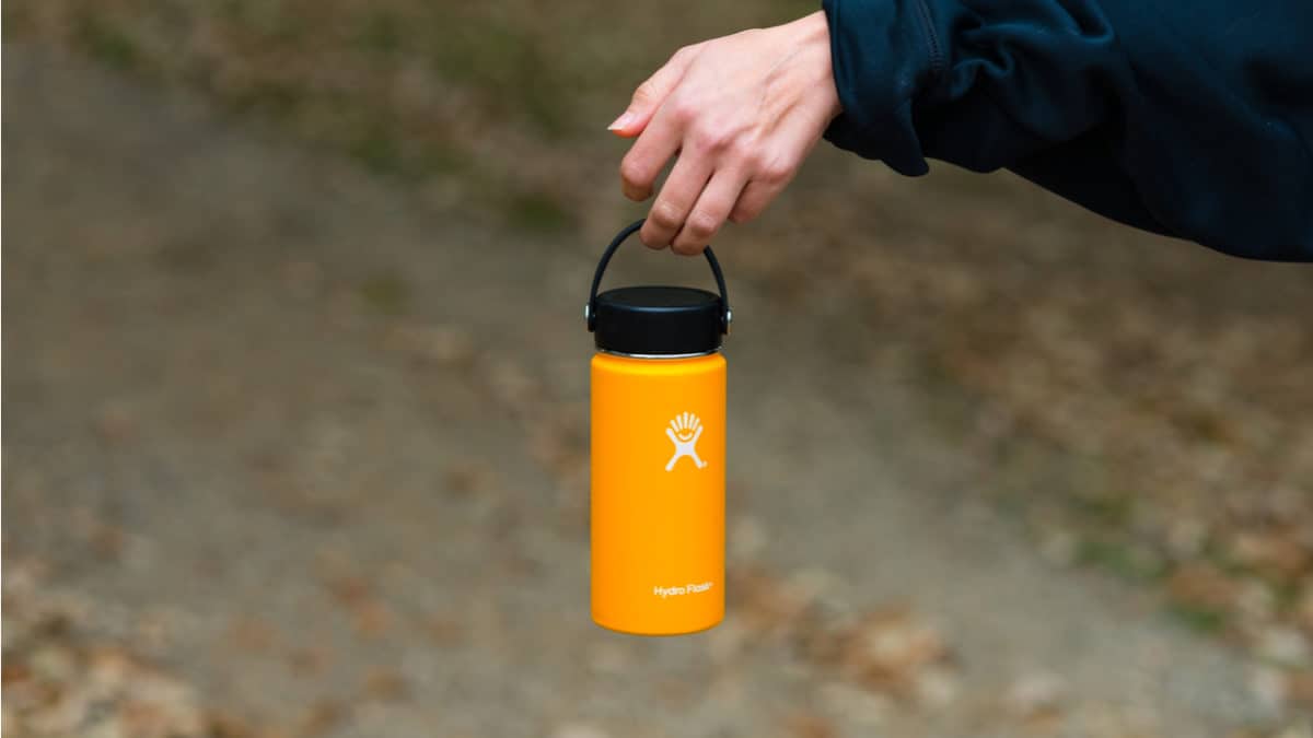 Female hiker holds a Hydro Flask