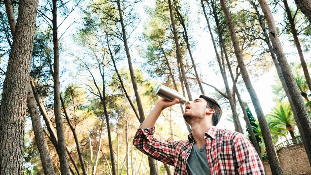 Hiker drinking out of a stainless steel bottle