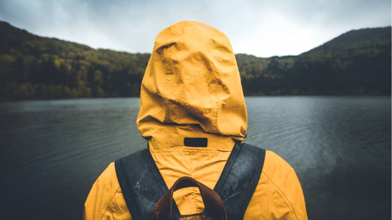 Hiker wears a rain jacket in rain