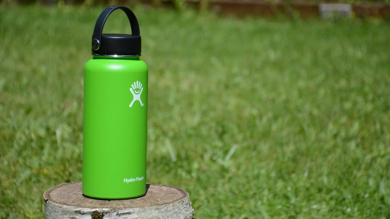 Green Hydro Flask bottle in a yard