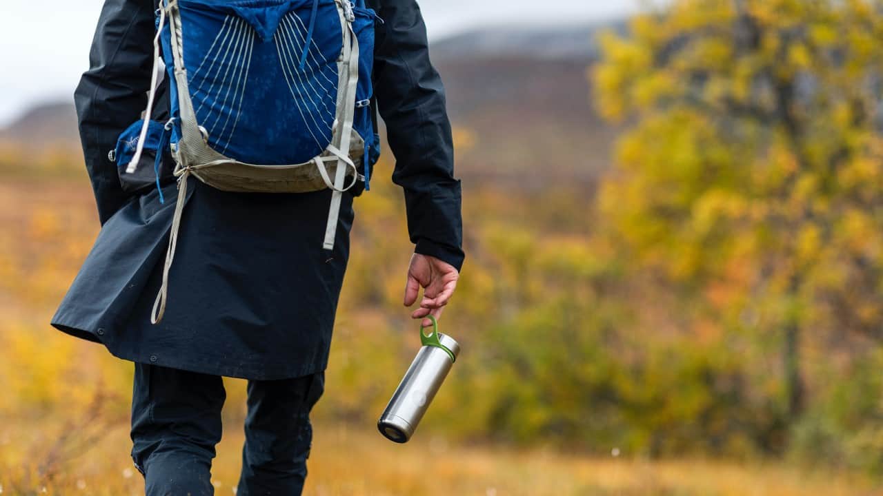 Male hiker carries bottle