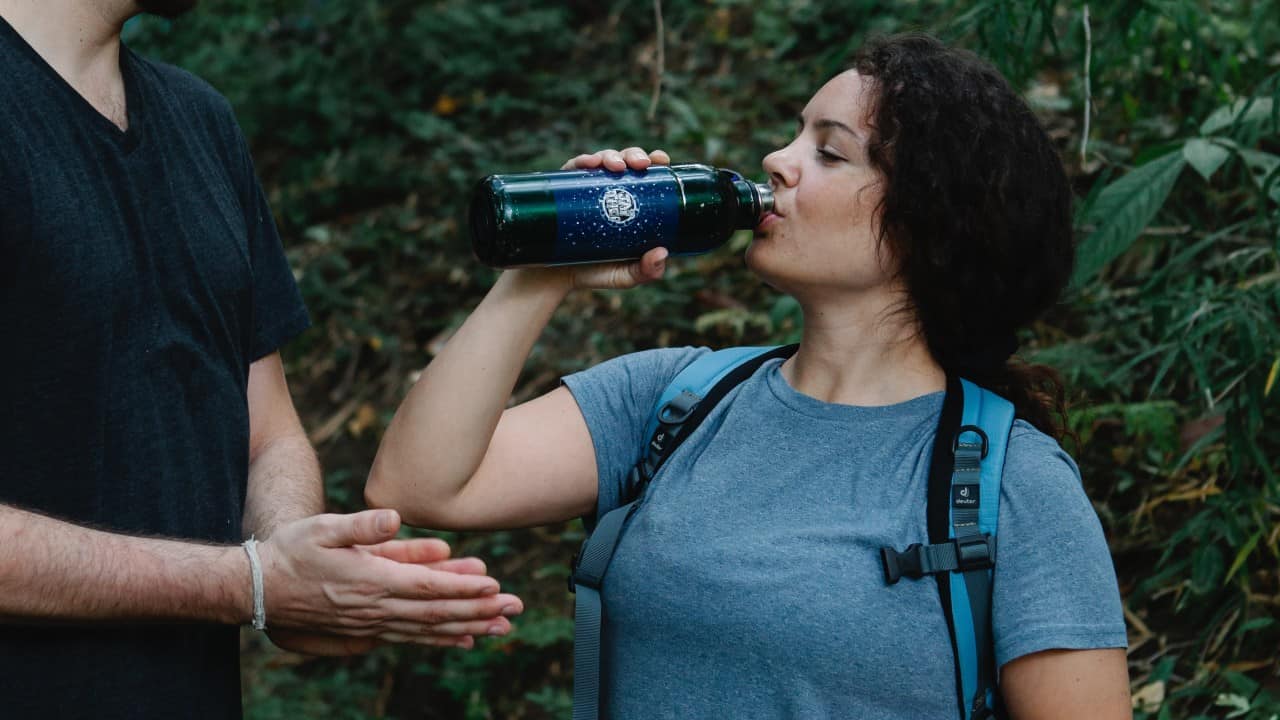 Hiker drinks out of a big bottle