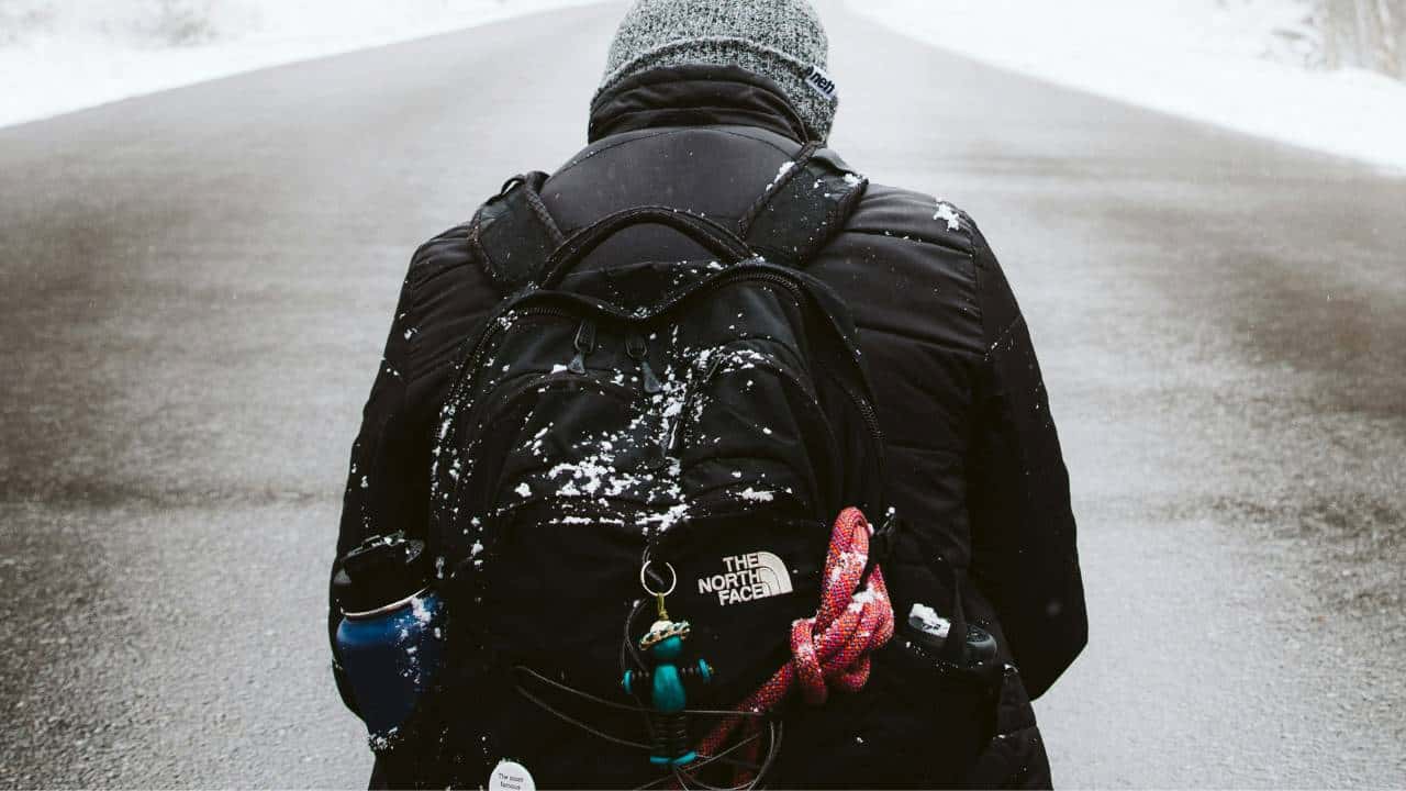 A man carrying the North Face backpack in a winter setting