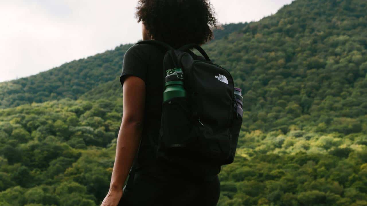 A woman wearing the North Face backpack while hiking