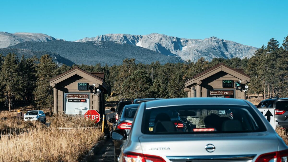 A line of cars wait at the entrance of Rocky Mountain National Park, Colorado, on an autumn morning