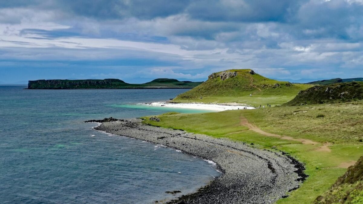 Rocky beach and green grass on Isle of Skye