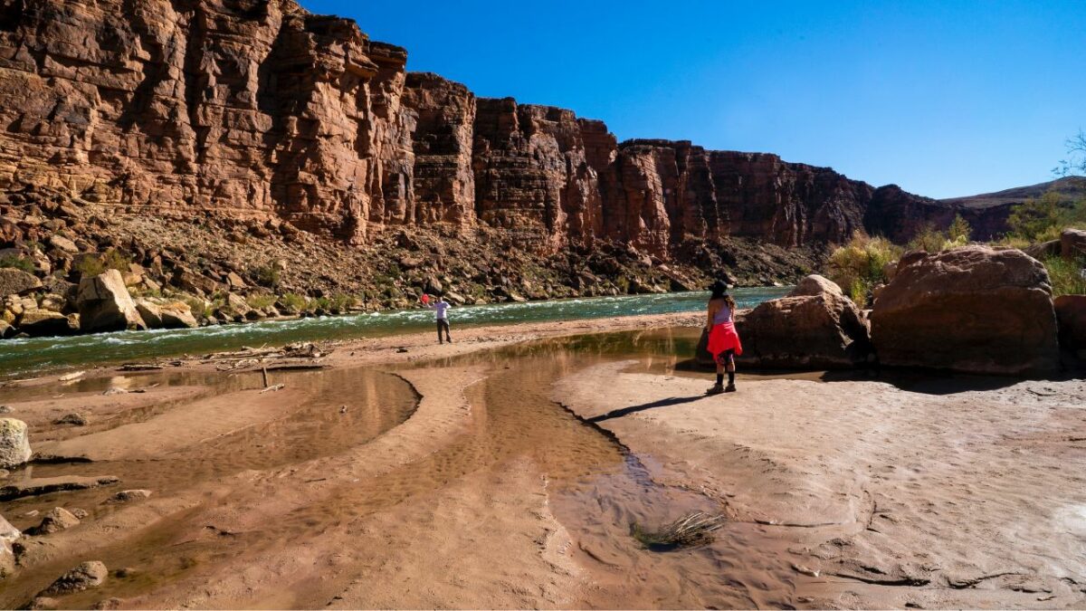 Campers playing frisbee next to the Colorado river in Nevada