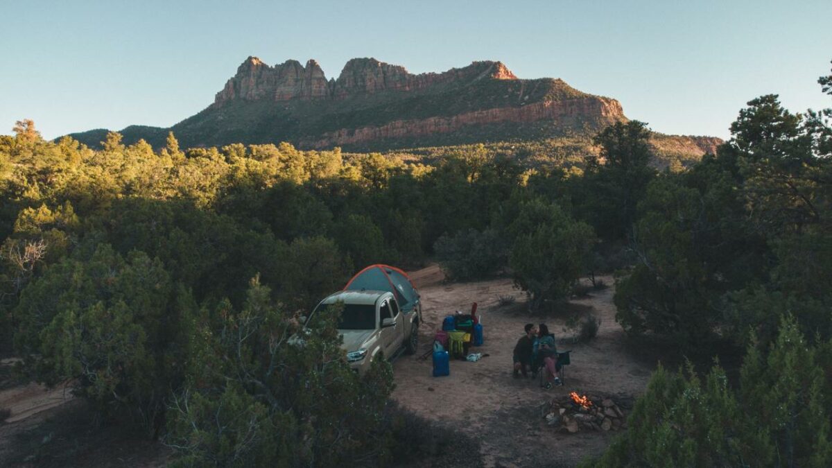 Dispersed campers in Zion National Park sitting next to a campfire and tent