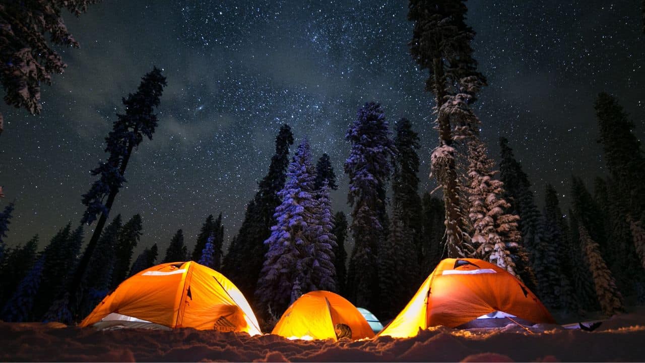 Three winter tents at a snowy dispersed camping area in Sierra National Forest