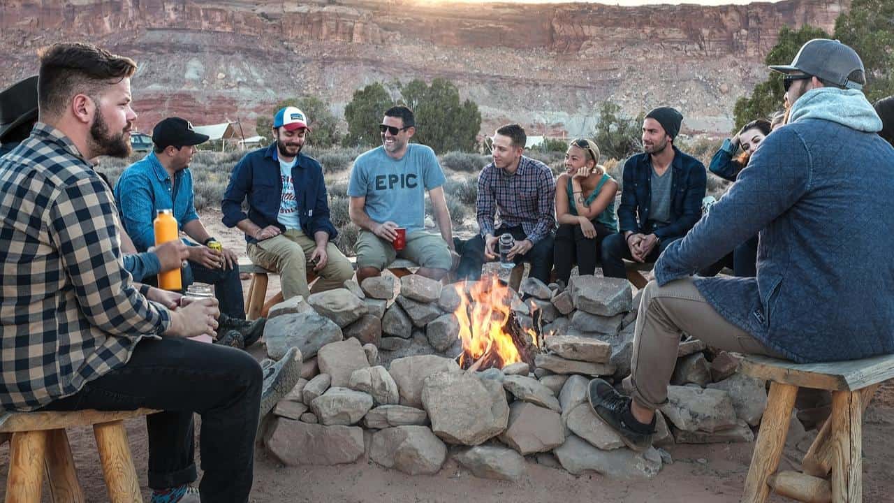 A group of campers around a campfire at a campsite in the US