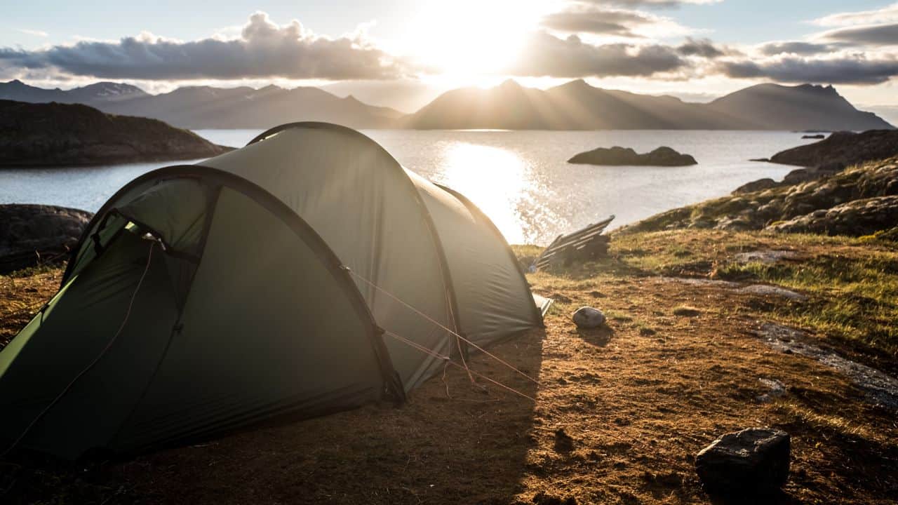 Wild camping tent on a cliff overlooking a bay