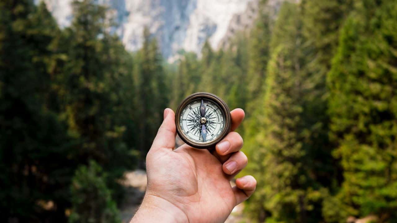 Camper holding a compass in the wilderness