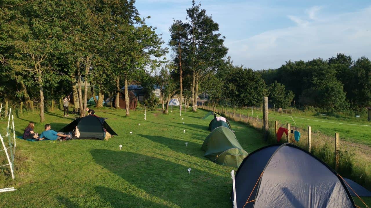People camping in tents on a grass field at Drymen camping