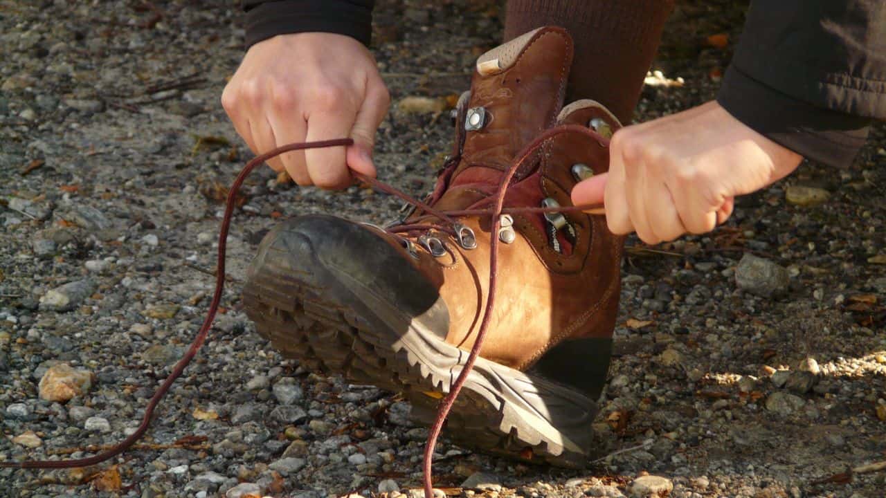 A man lacing his trekking boot