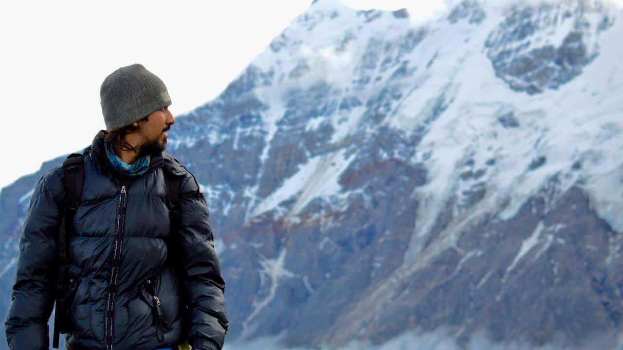 A man wearing a black hiking jacket mountaineering