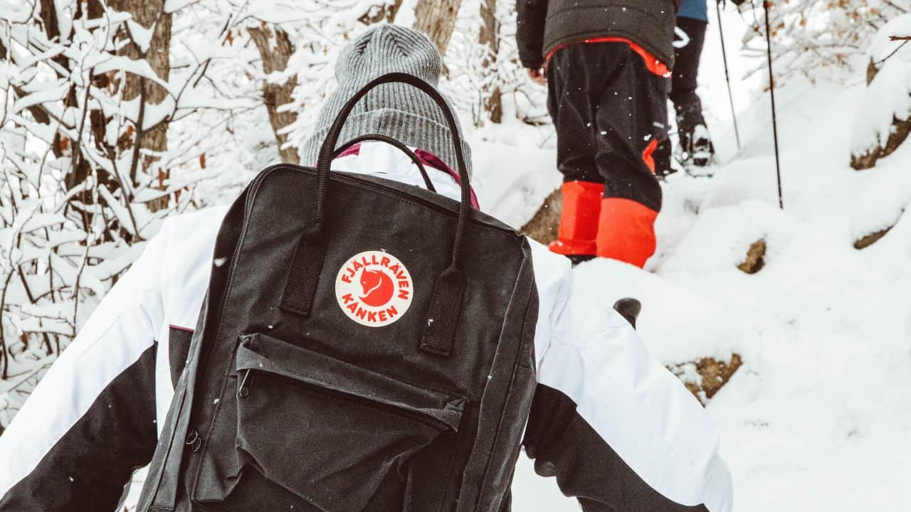 Man with a Fjallraven backpack hiking in the snow